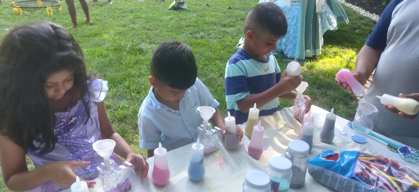 Children making sand art together outdoors